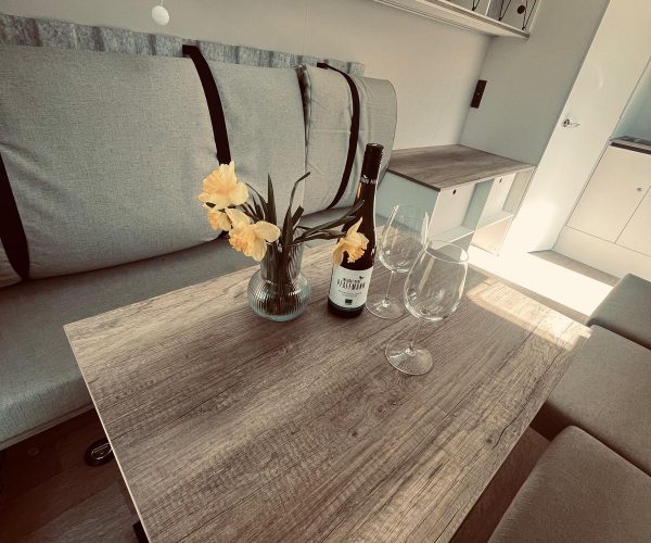 Detailansicht einer gemütlichen Essecke in einem modern eingerichteten Wohnmobil.